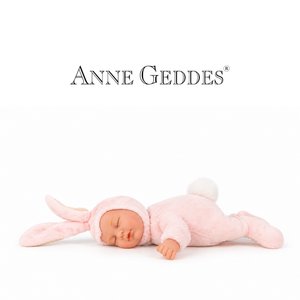 A sleeping doll dressed in a soft pink bunny suit with long ears and a fluffy white tail, lying on a white background. The brand name 'ANNE GEDDES' is printed above.