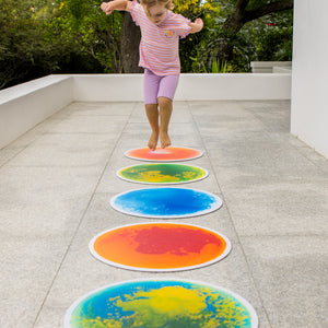 Child playing on colourful tiles outdoors