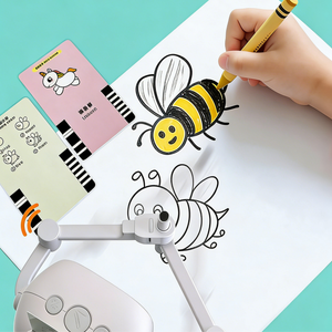 Hand holding a pencil over a bee drawing on a coloring book with a magnifying device.