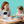 Woman and child with a robot drawing together on a table.
